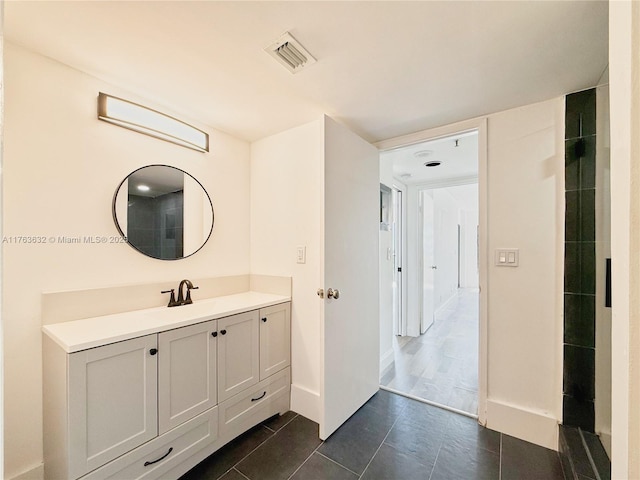 bathroom featuring vanity, baseboards, visible vents, and tile patterned flooring