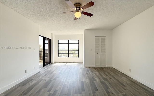 empty room featuring a textured ceiling, wood finished floors, baseboards, and ceiling fan