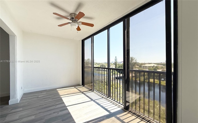 unfurnished sunroom with ceiling fan