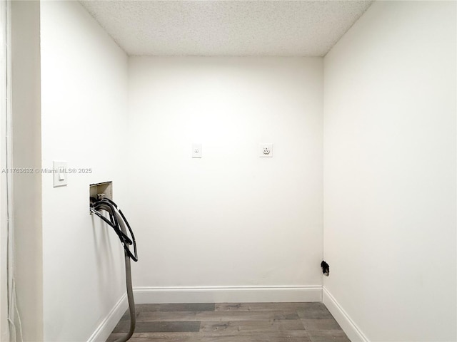 washroom featuring washer hookup, a textured ceiling, wood finished floors, baseboards, and laundry area