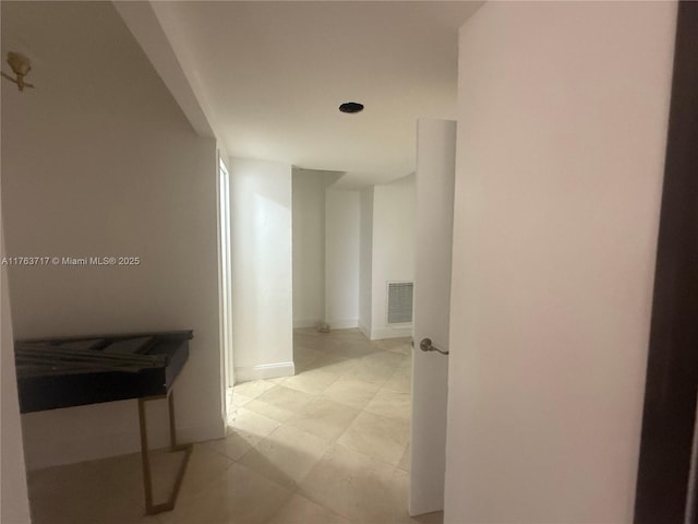 hallway with baseboards and visible vents