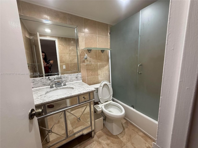 bathroom with tile walls, toilet, and vanity