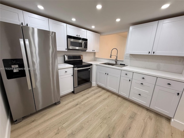 kitchen with light wood-style flooring, recessed lighting, a sink, stainless steel appliances, and light countertops