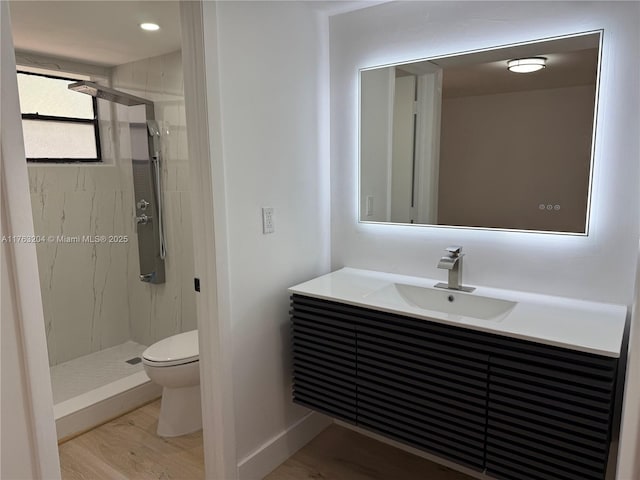 full bathroom with a shower stall, toilet, vanity, and wood finished floors