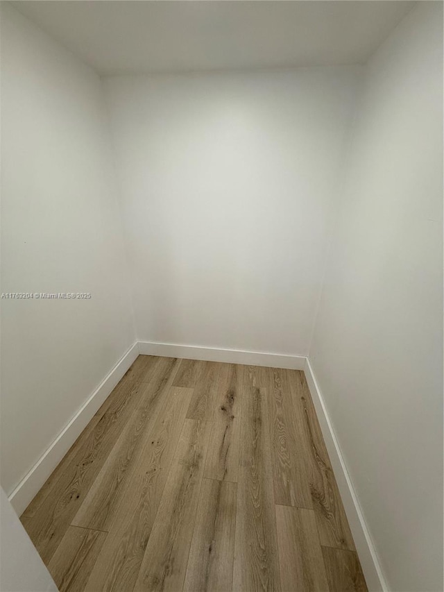 empty room featuring light wood-type flooring and baseboards