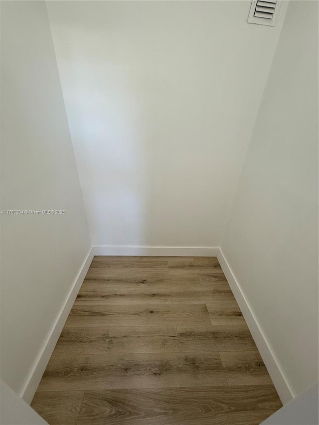 interior space with visible vents, baseboards, and wood finished floors