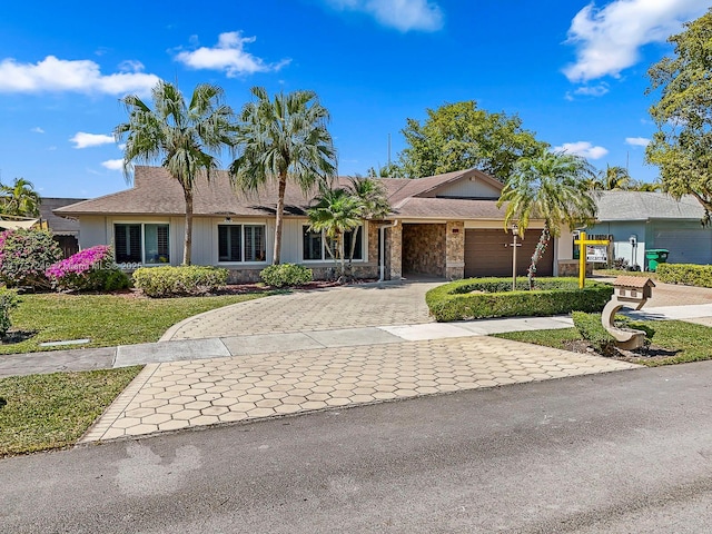 ranch-style home with decorative driveway and a garage