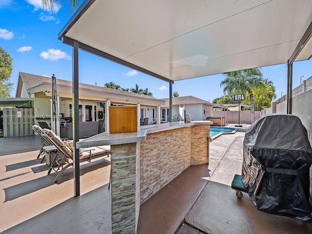 view of patio / terrace with a fenced backyard, a fenced in pool, and outdoor dry bar