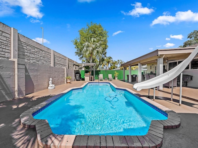 view of pool with fence, a patio area, a fenced in pool, and a water slide