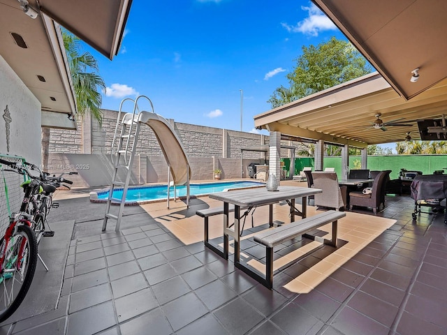 view of patio with outdoor dining area, a fenced in pool, and a fenced backyard