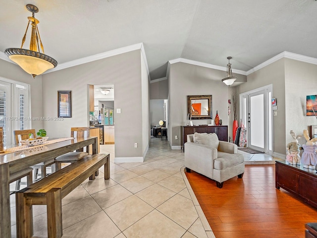 dining area featuring light tile patterned flooring, baseboards, crown molding, and lofted ceiling