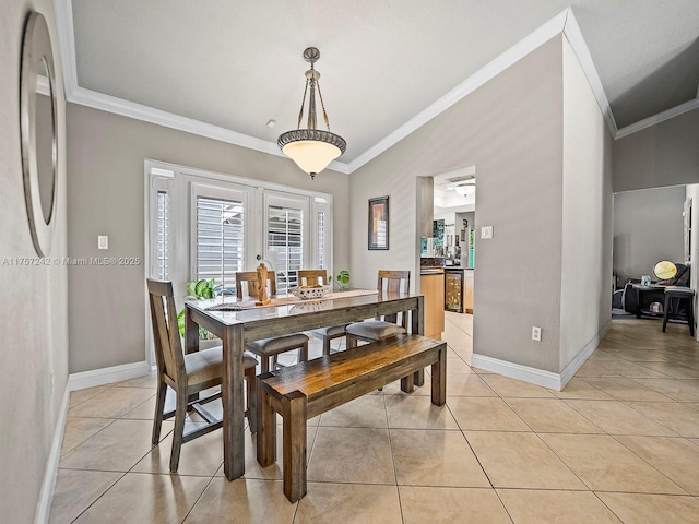 dining room with baseboards, light tile patterned flooring, crown molding, and vaulted ceiling