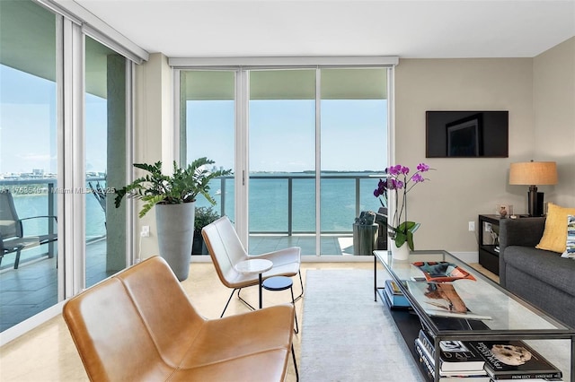 living room with a wall of windows, baseboards, and a water view