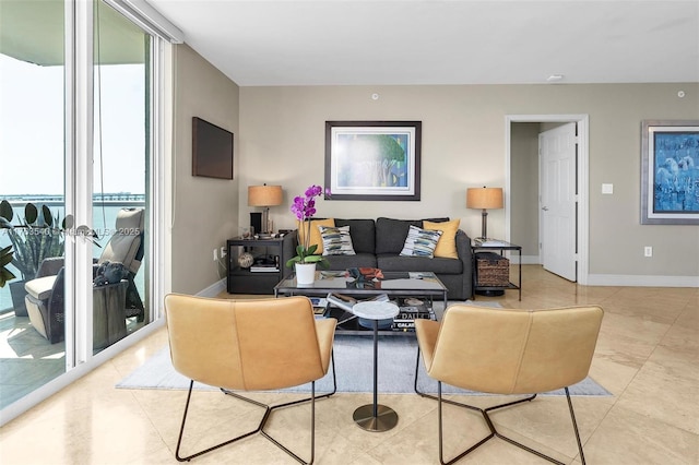 living room with light tile patterned floors, floor to ceiling windows, and baseboards