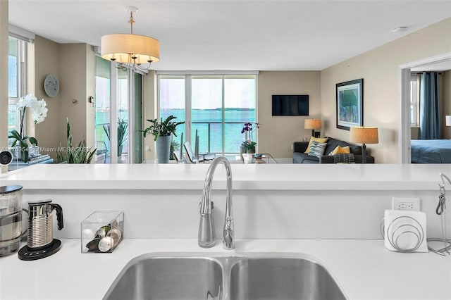 kitchen with a sink, open floor plan, and light countertops