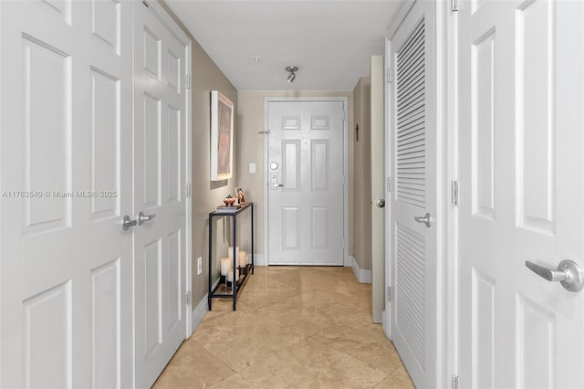 hall with baseboards and light tile patterned flooring