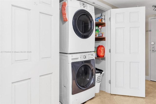 laundry room featuring stacked washer / drying machine, light tile patterned flooring, and laundry area