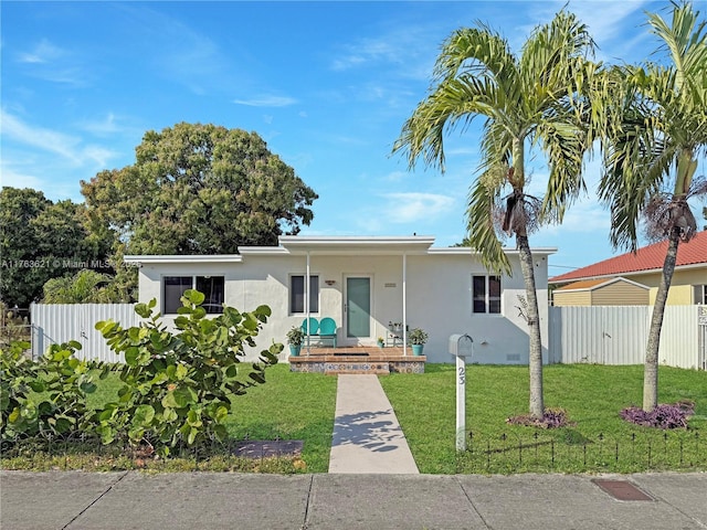 view of front of home featuring stucco siding, a front yard, and fence