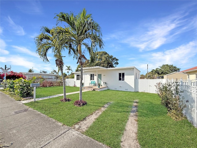 bungalow-style home featuring a front lawn, fence, and stucco siding