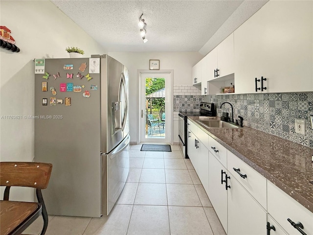 kitchen featuring light tile patterned flooring, stainless steel fridge with ice dispenser, electric stove, and a sink