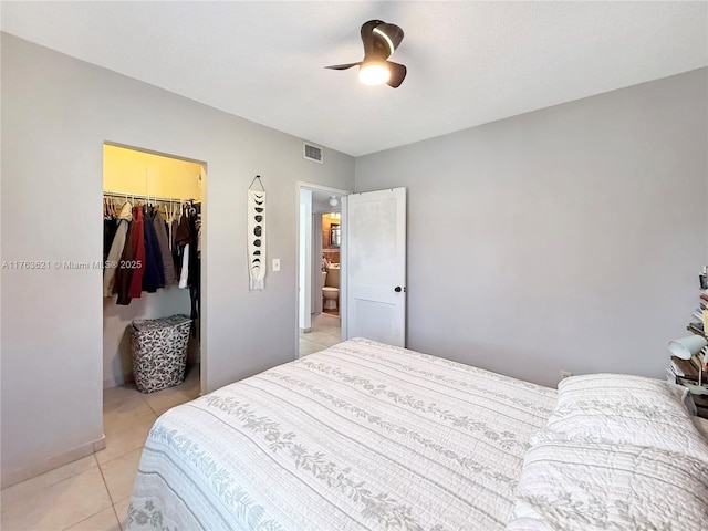 bedroom featuring light tile patterned floors, visible vents, ceiling fan, a spacious closet, and a closet