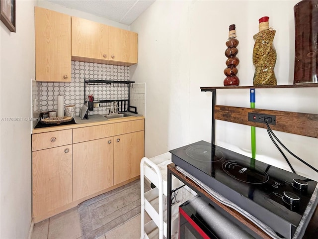 kitchen featuring a sink, decorative backsplash, light tile patterned flooring, and light brown cabinetry