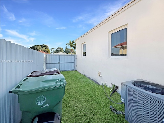 view of yard featuring central air condition unit and fence