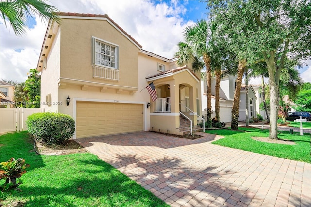 mediterranean / spanish-style house featuring a tile roof, a front yard, stucco siding, decorative driveway, and an attached garage