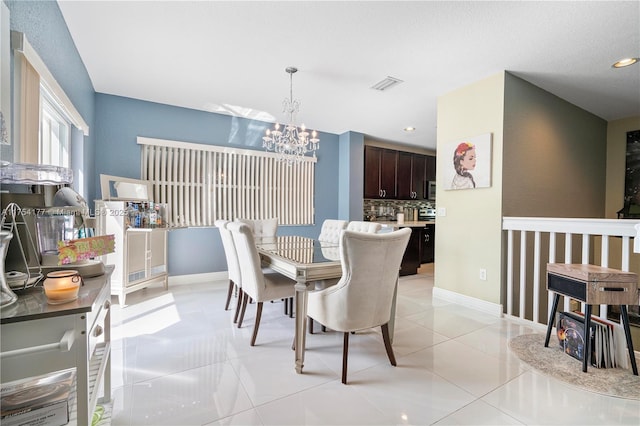 dining room featuring a chandelier, visible vents, baseboards, and light tile patterned floors