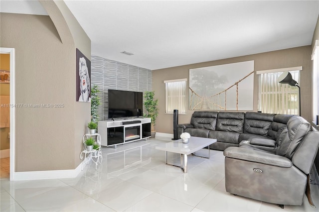 tiled living room with visible vents and baseboards