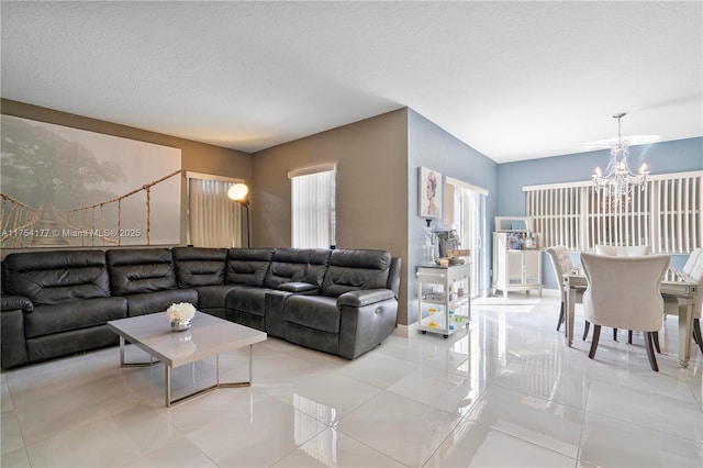 living area featuring an inviting chandelier, light tile patterned flooring, and a textured ceiling