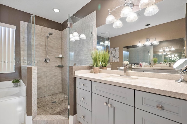 full bathroom featuring a bath, vanity, and walk in shower