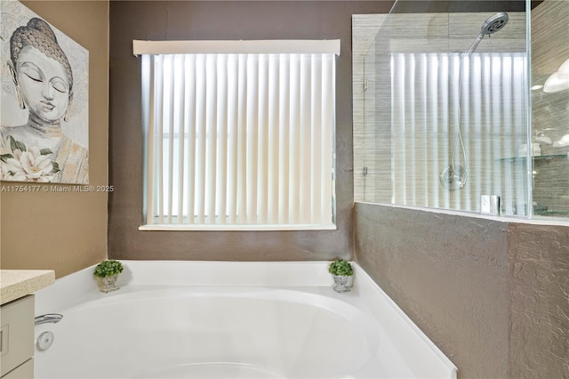 full bath with vanity, a garden tub, and tiled shower