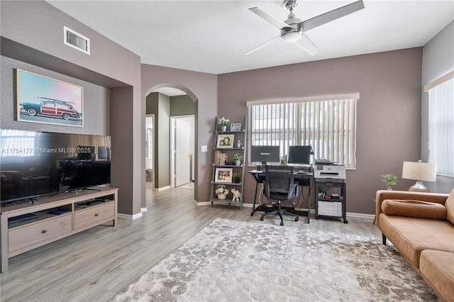 office area featuring visible vents, arched walkways, wood finished floors, and a ceiling fan