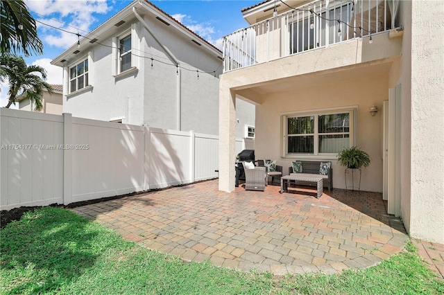 view of patio featuring an outdoor hangout area, a balcony, and fence