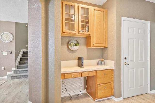 interior space with baseboards, wood finished floors, vanity, and a textured wall