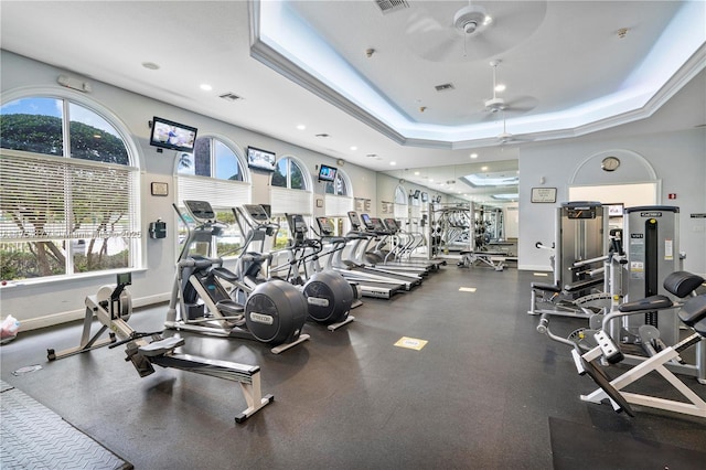 gym with visible vents, baseboards, a tray ceiling, recessed lighting, and ceiling fan