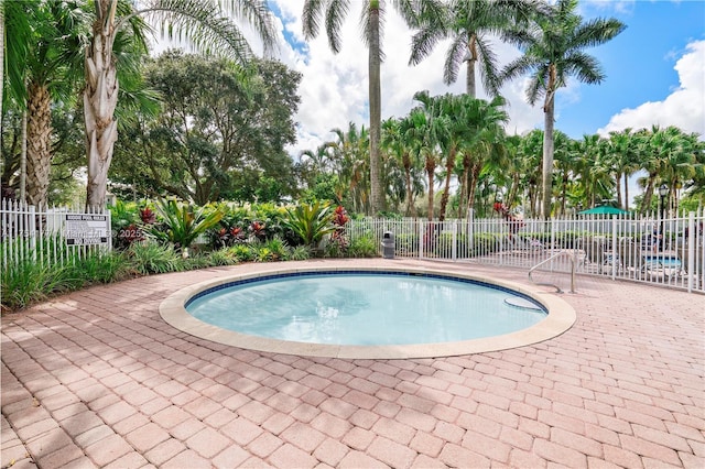 view of swimming pool featuring a patio, a pool, and fence