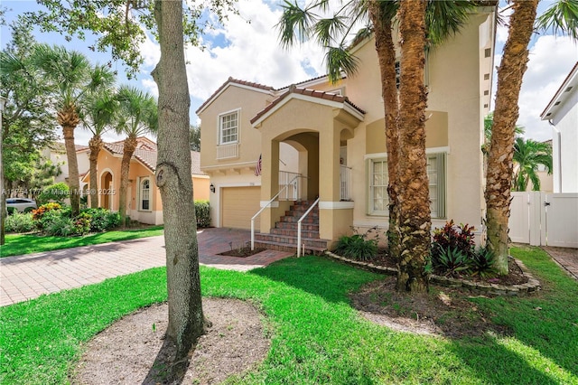 mediterranean / spanish-style house featuring fence, driveway, stucco siding, a garage, and a tile roof