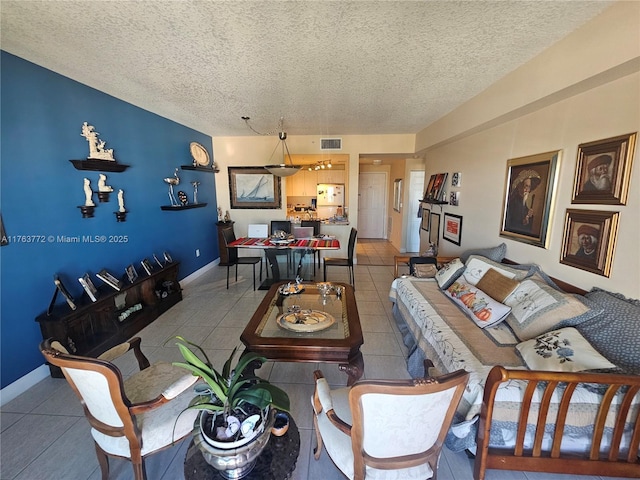 tiled living area featuring baseboards, visible vents, and a textured ceiling