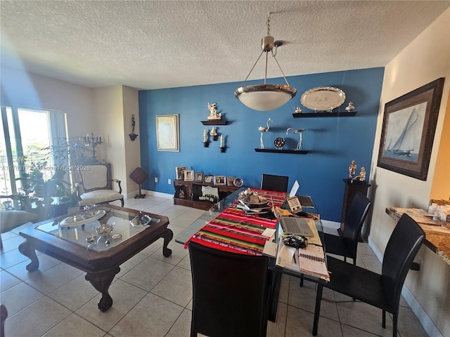 dining space featuring tile patterned flooring, baseboards, and a textured ceiling