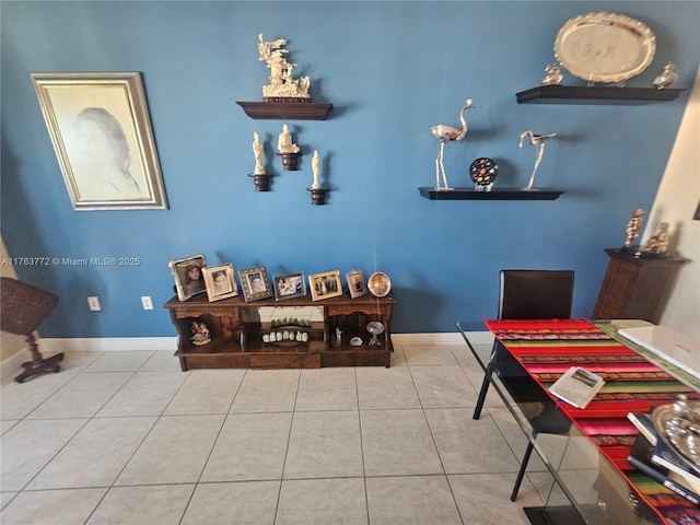 tiled dining area featuring baseboards