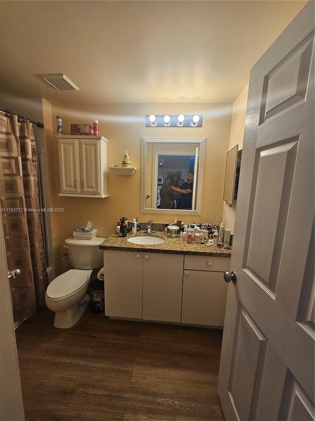 full bathroom with visible vents, toilet, a shower with curtain, wood finished floors, and vanity