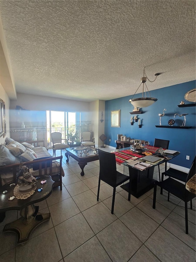 dining space with tile patterned flooring, baseboards, and a textured ceiling