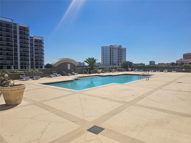 community pool featuring a view of city and a patio area