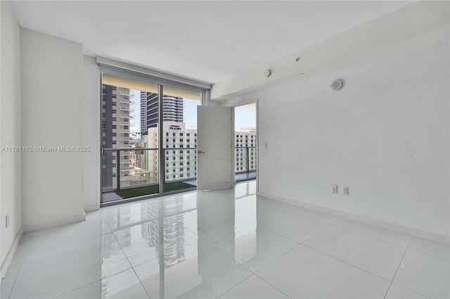 1100 S Miami Ave Unit 1103, Miami, FL 33130 - tiled spare room featuring floor to ceiling windows, a city view, and a smoke detector