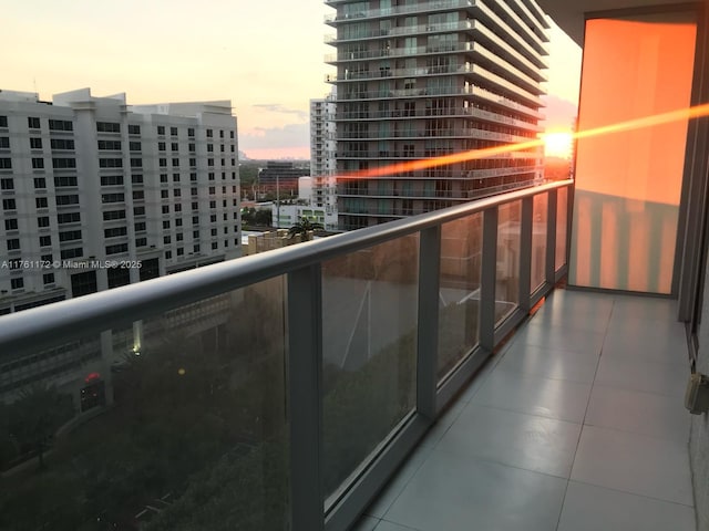 balcony at dusk featuring a city view