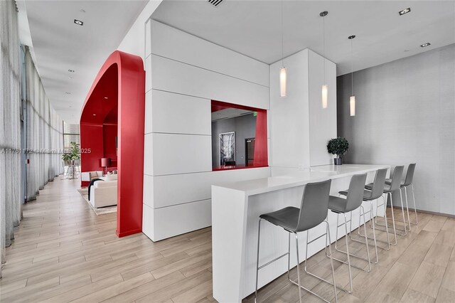 1100 S Miami Ave Unit 1103, Miami, FL 33130 - kitchen with light wood-type flooring, a breakfast bar, and decorative light fixtures