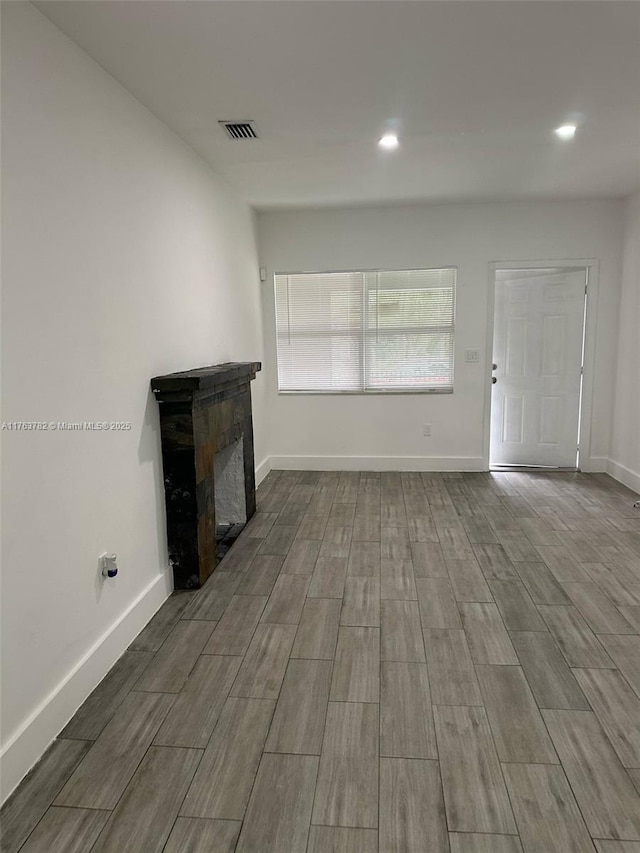 unfurnished living room featuring recessed lighting, a fireplace, visible vents, and baseboards