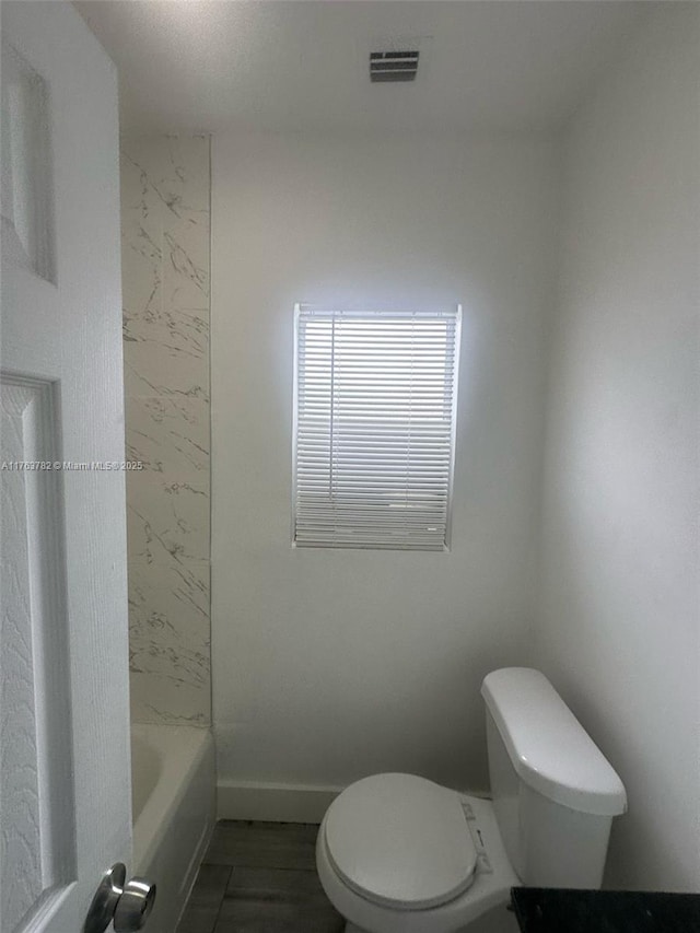 full bathroom with toilet, baseboards, and visible vents